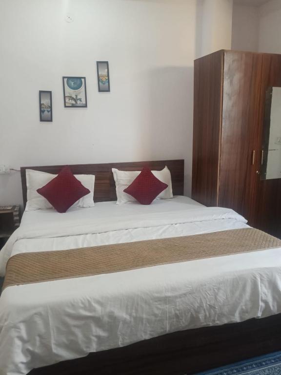 a bedroom with a large bed with red pillows at Hotel Rajpal in Jaipur