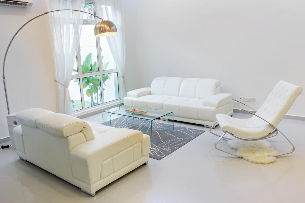 a living room with two white chairs and a couch at Shamrock Beach Villas 15 Seaview in George Town