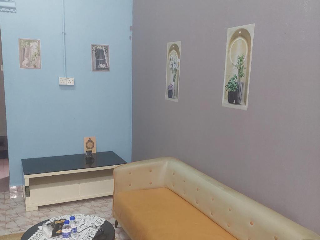 a room with a bed and a table and a tub at Sumud Bonda Homestay in Kuala Kerai