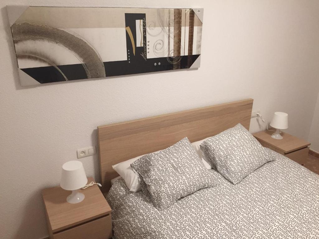 1 cama con 2 almohadas y una foto en la pared en Apartamento Torre del Salvador, en Teruel