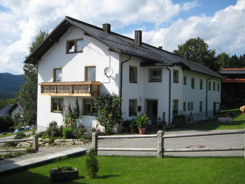 una casa blanca con una valla delante en Pension zum Lusenblick en Mauth
