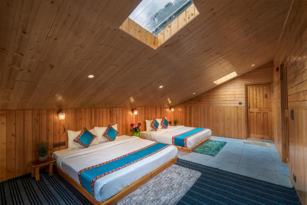 two beds in a room with wooden walls at khwaab sojha in Alsindhi