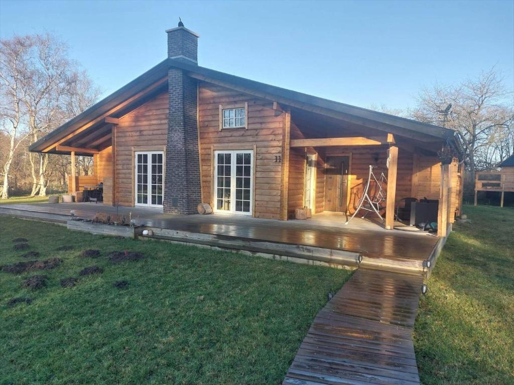 a log cabin with a deck in the grass at L40-Rodby-Glentevej-11 in Rødby