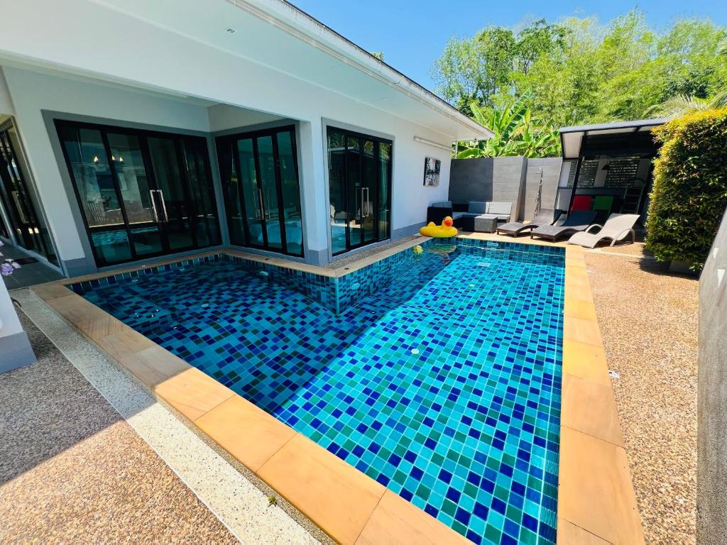 a swimming pool with blue tile in a house at Duangtham luxury Pool Villa in Ban Khlong Haeng