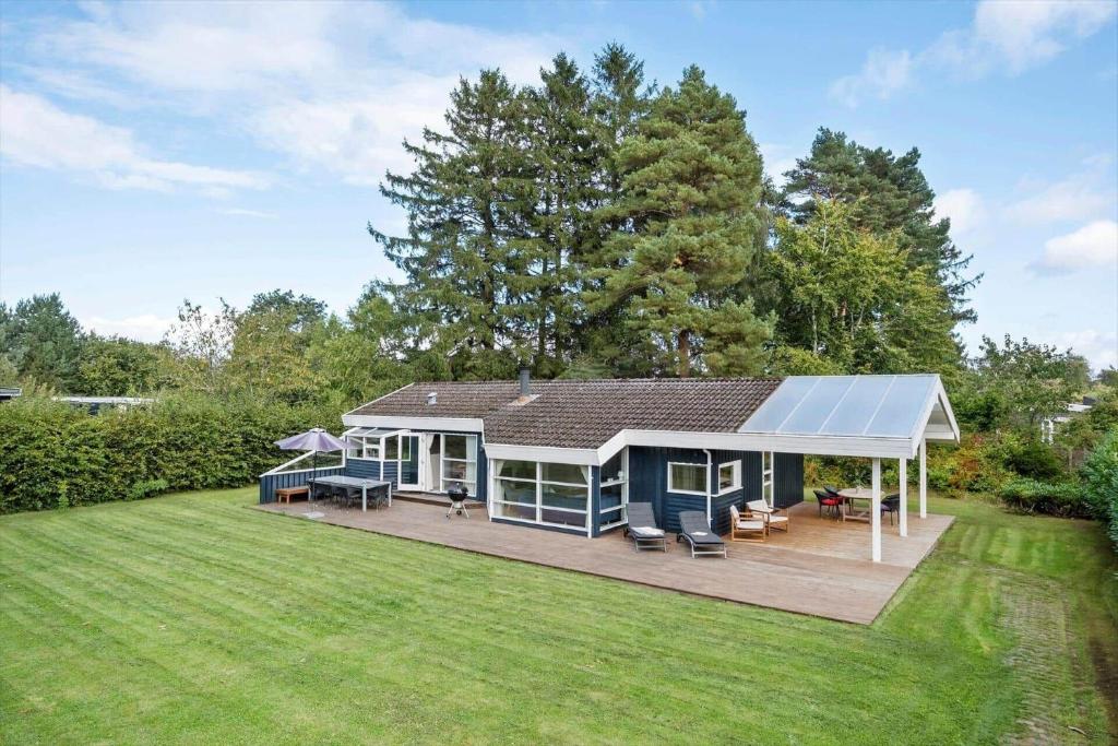 a house with a solarium on a lawn at 1627-Dronningmolle-Svalevej-3 in Dronningmølle