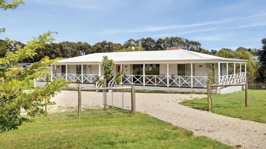 a white house with a fence in front of it at Malmsbury Cottage in Malmsbury