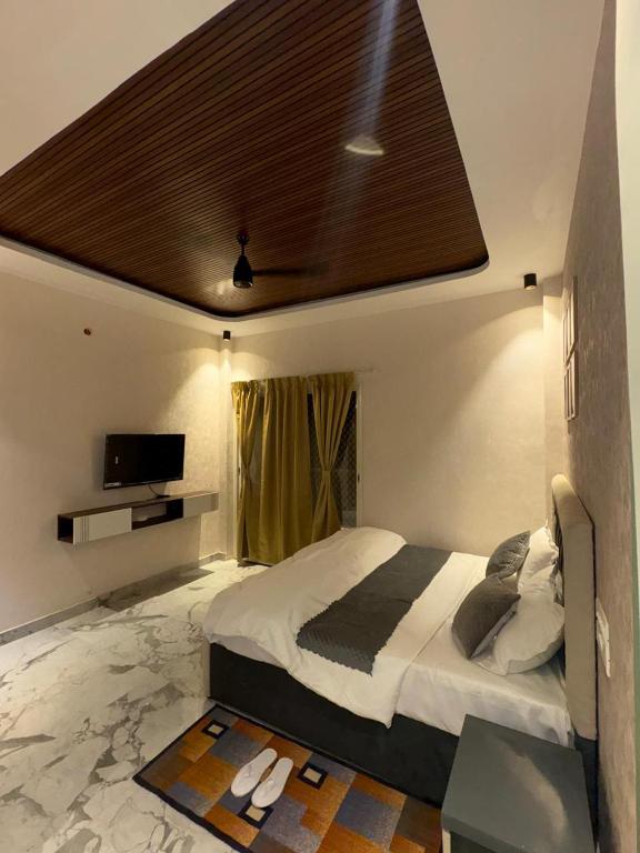 a bedroom with a large bed with a brown ceiling at The Water Box in Kānpur