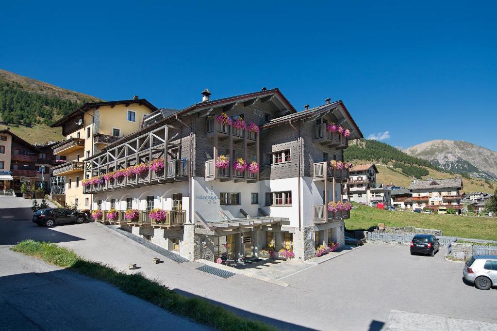 a large building with flowers on the balconies of it at Hotel Marzia in Livigno