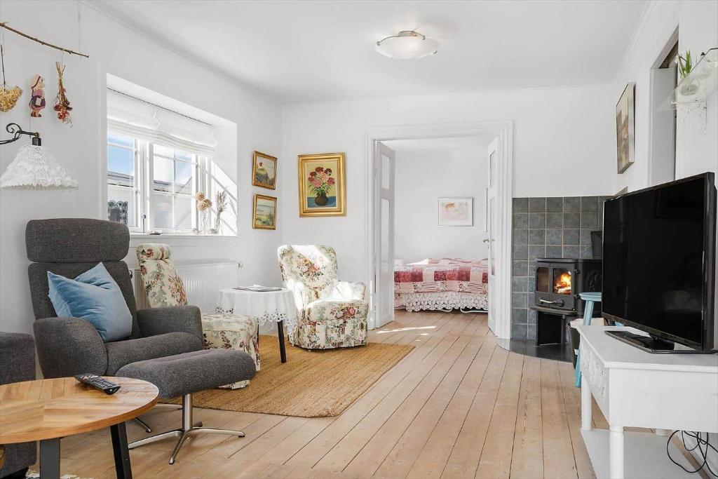 a living room with a tv and a couch and chairs at 70303-Ulfborg-Jagtvejen-4 in Ulfborg