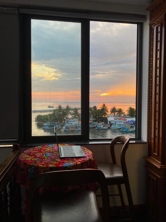 a laptop sitting on a table in front of a window at Tôm Tít Homestay in Phú Quốc