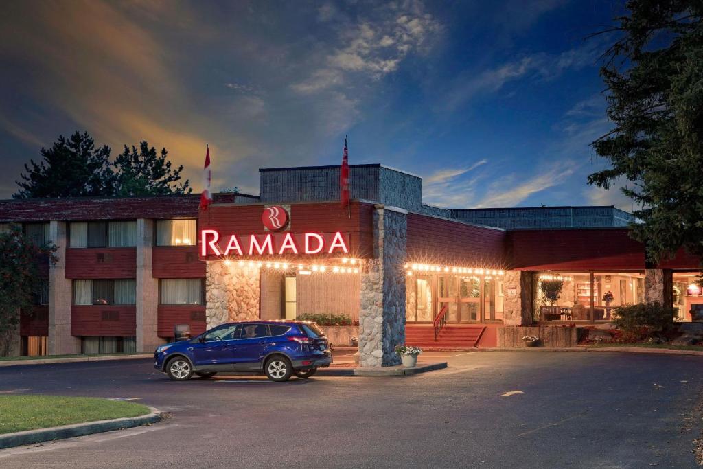 a car parked in a parking lot in front of a hotel at Ramada by Wyndham Pinewood Park Resort North Bay in North Bay