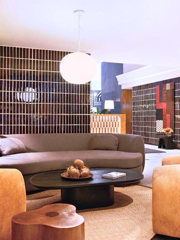 A lounge seating area with a sofa, rounded stools, and a low coffee table.
