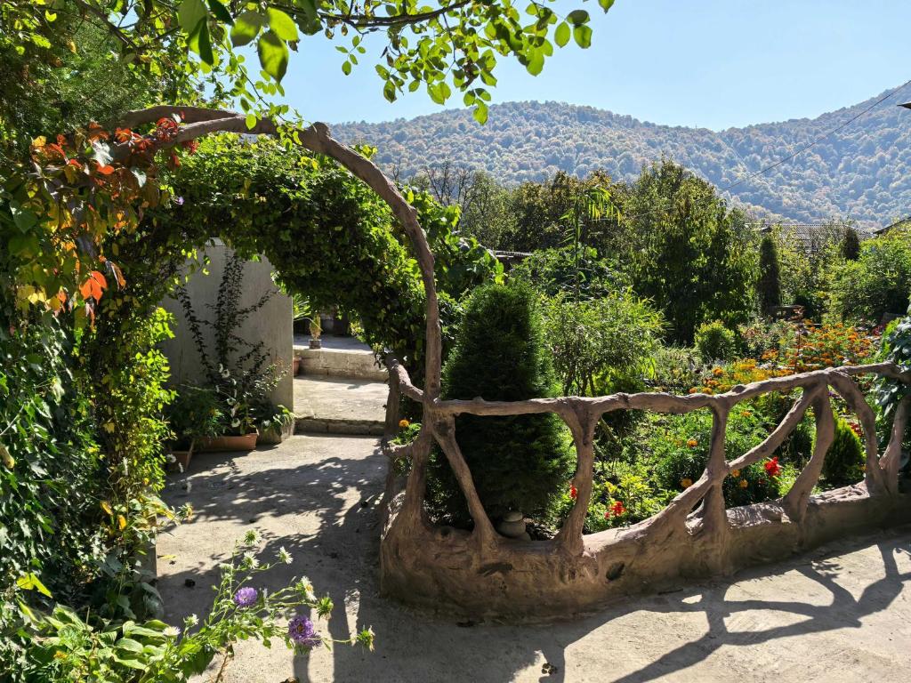 an arch in a garden with flowers and plants at Green Park Guest House in Dilijan