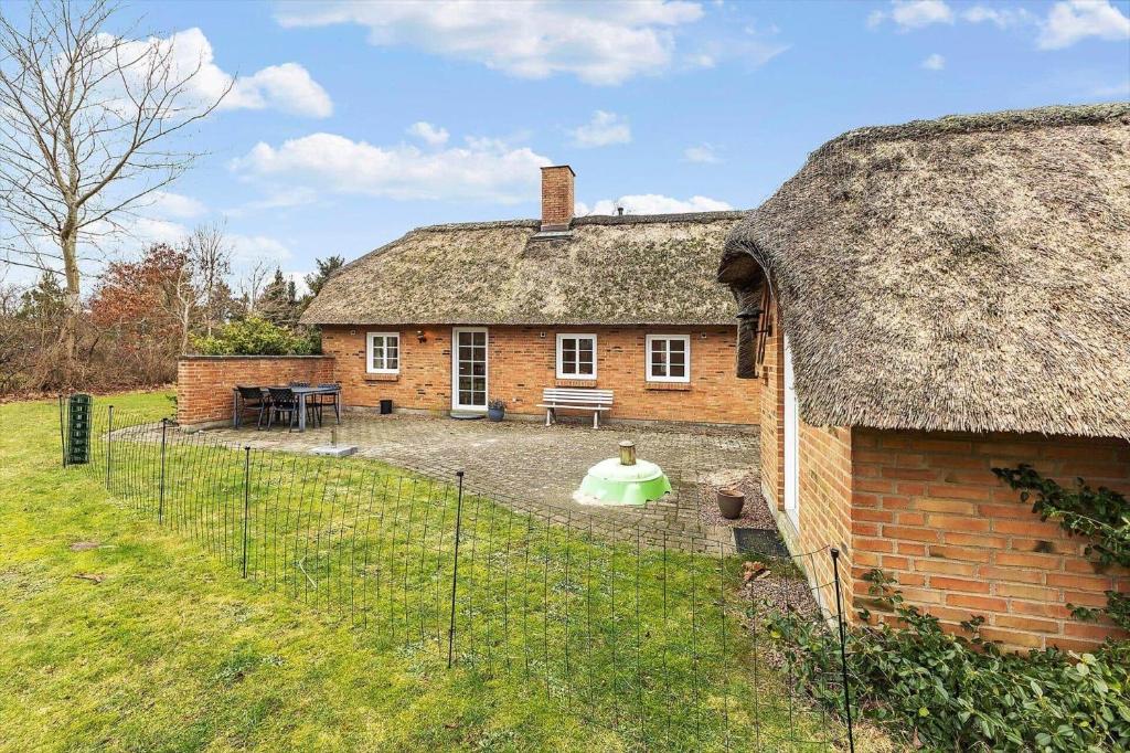 an old brick house with a grass roof at 30848-Ulfborg-Valmuevej-286 in Ulfborg