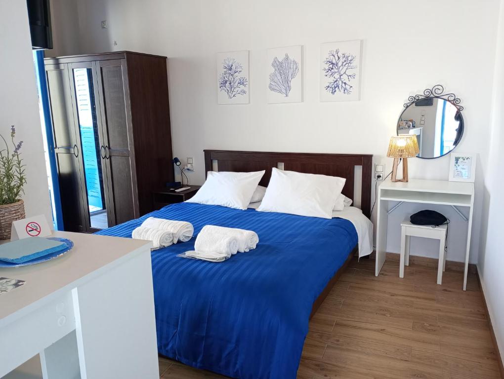 a bedroom with a blue bed with two white pillows at Rooms of Nectar in Poros