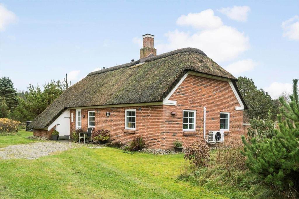 an old brick house with a thatched roof at 10808-Ulfborg-Vester-Mosevej-84 in Ulfborg
