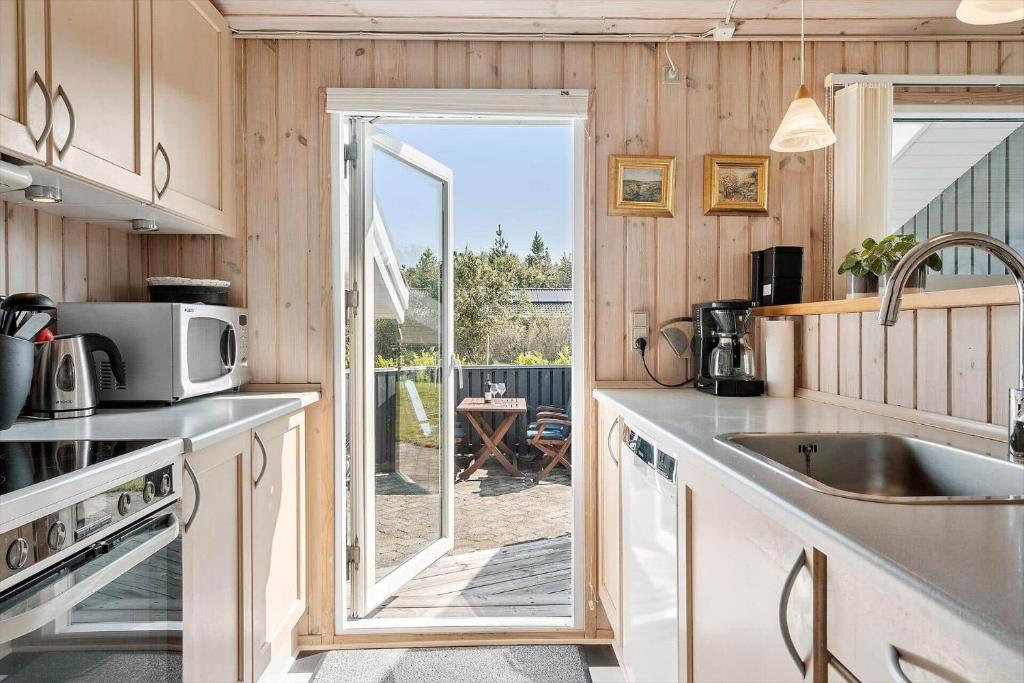a kitchen with a door leading to a patio at 30872-Ulfborg-Bellisvej-514 in Ulfborg