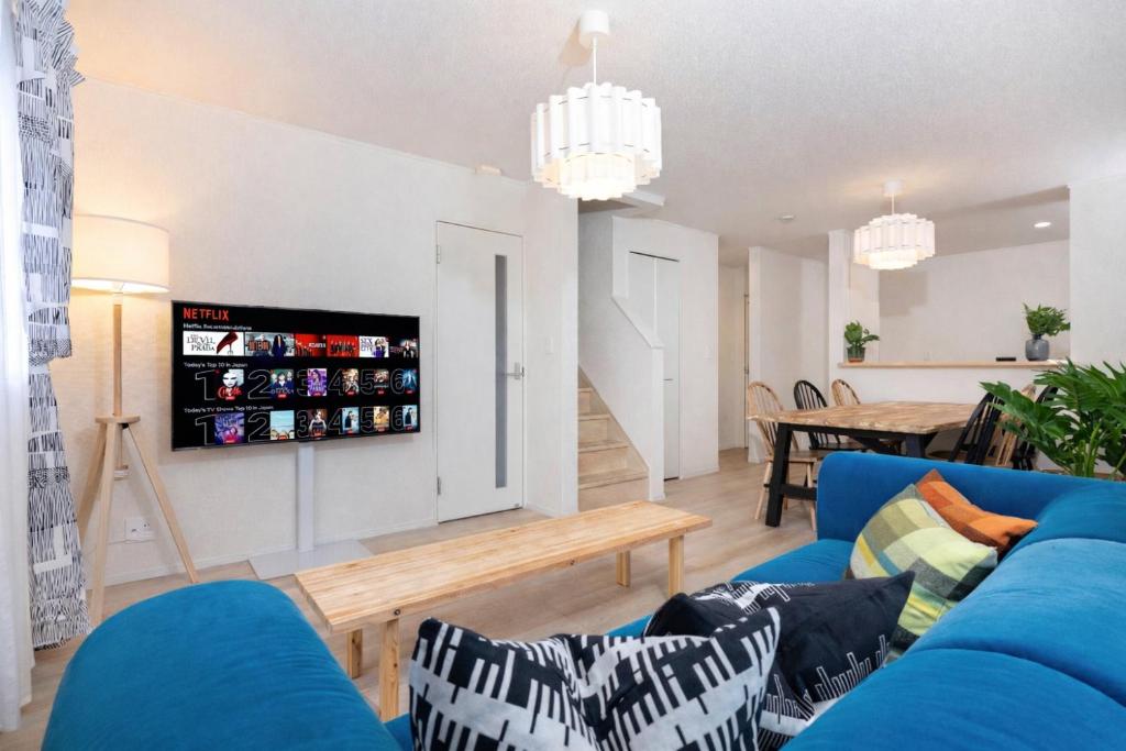 a living room with a blue couch and a table at Villa Gotemba Holidays in Gotemba