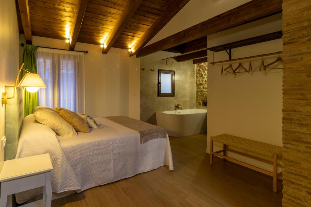 a bedroom with a bed and a tub in a room at Refugi dels Somnis - Turismo con encanto en Onda in Onda