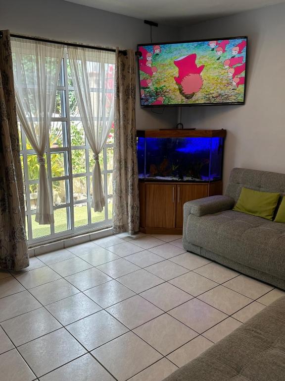 a living room with a couch and a flat screen tv at Casita Océano in La Paz