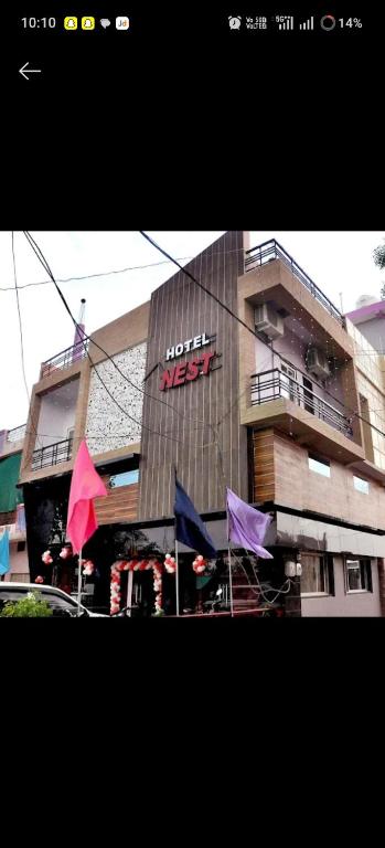 a building with a sign on the side of it at Hotel Nest in Nagda