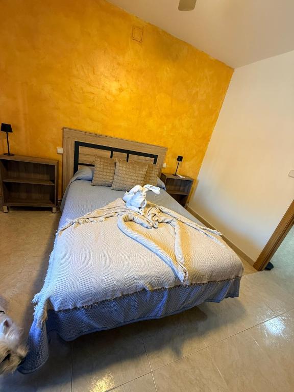 a bedroom with a bed and a yellow wall at Casa Pumba in San Martín de la Vega