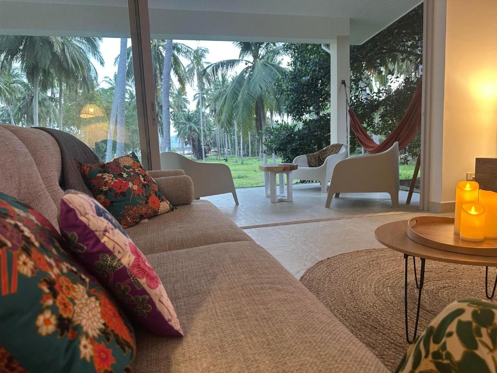 a living room with a couch and a table at Villa Colette in Ban Hua Laem Ma So