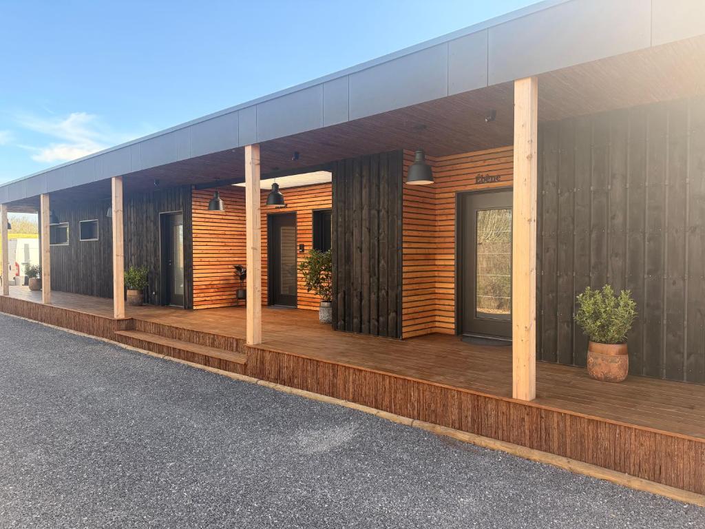 a building with a deck with potted plants on it at Refuge des Dunes in Marck
