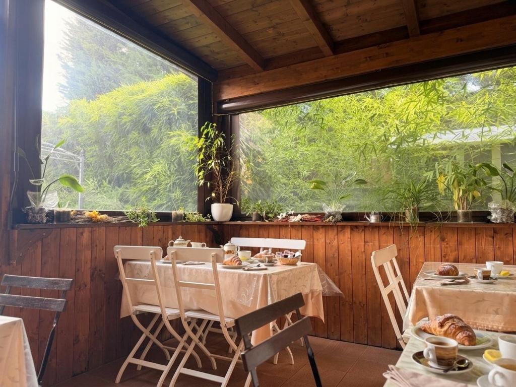 a dining room with two tables and a large window at Cameracaffè sul Lago in Arezzo