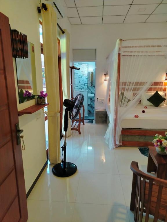 a hotel room with a bedroom and a bed at Robert Ayurveda Villa in Bentota