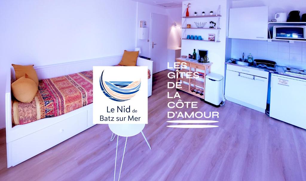 a room with a bed and a sign in a kitchen at LE NID DE BATZ SUR MER-Studio-Les Gîtes de la Côte d'Amour in Batz-sur-Mer