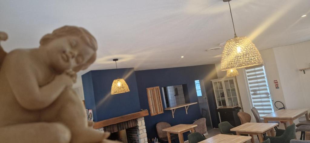 a woman in a room with tables and chairs at Hôtel restaurant ANGEL'S in Angles