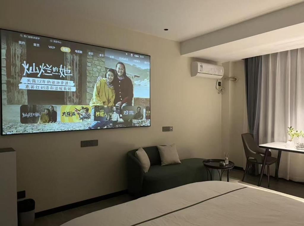 a hotel room with a tv on the wall at 梦息民宿 in Guyuan