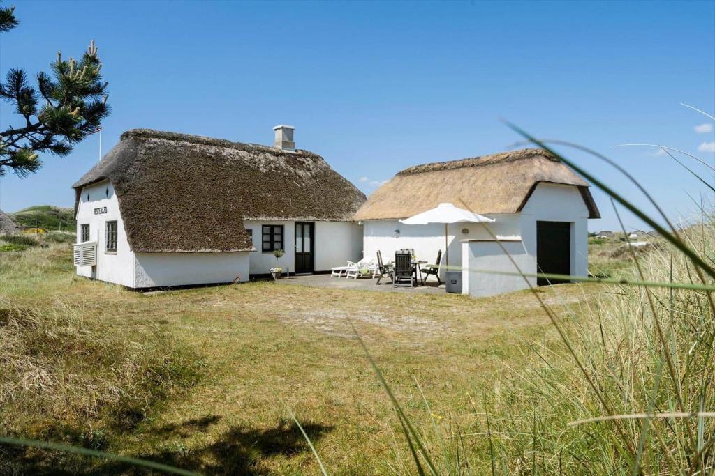 a white cottage with a thatched roof and a yard at 20157-Ulfborg-Revlingvej-8 in Ulfborg
