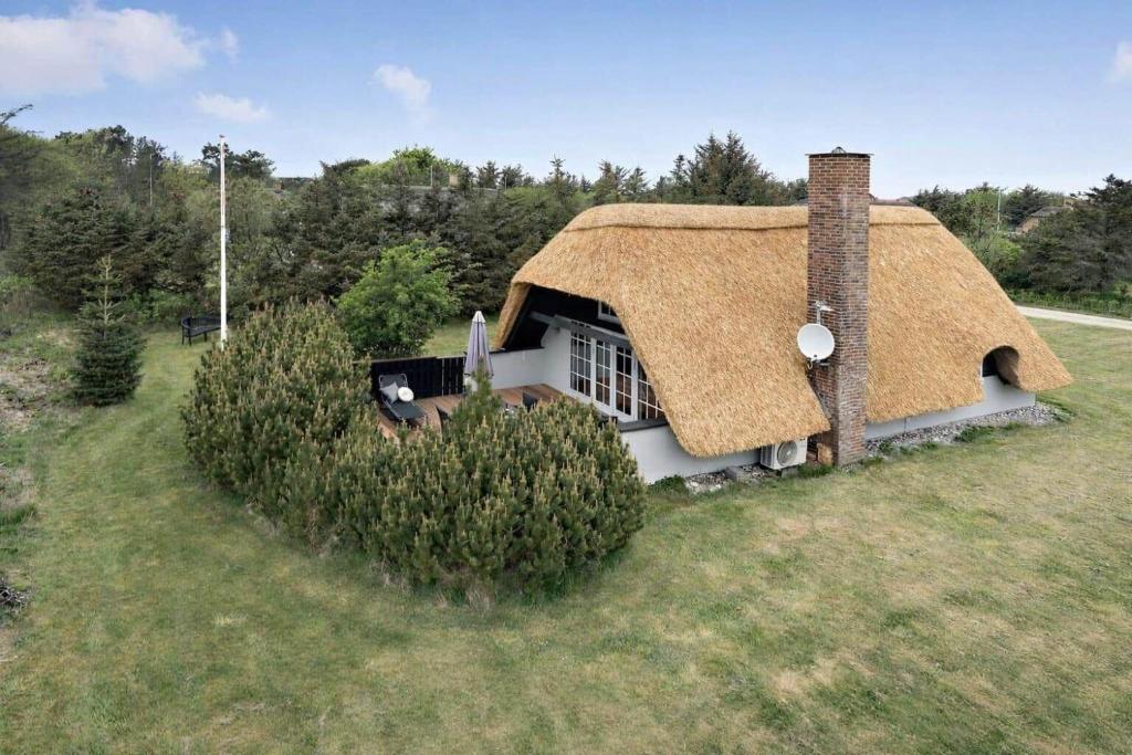 a house with a thatched roof on a field at 20362-Ulfborg-Sortebaervej-22 in Ulfborg