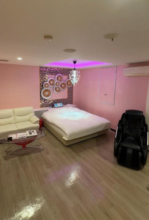 a bedroom with a large bed and a couch at ホテルパルシス大人専用 in Shiroishi