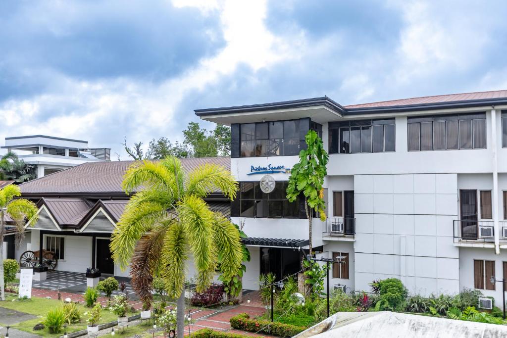 a building with a palm tree in front of it at Pietros Square in Butuan