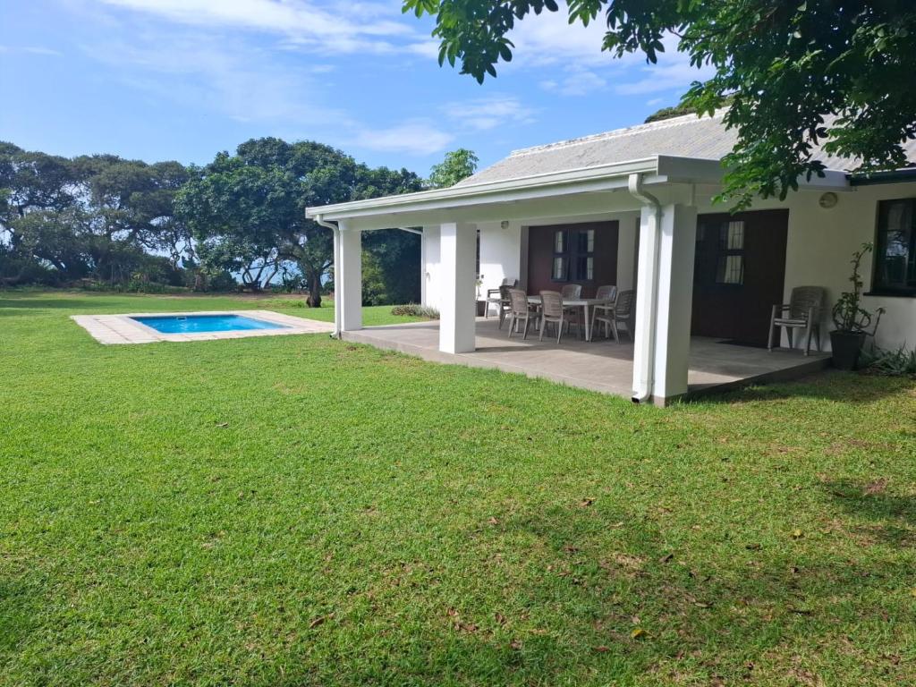 a house with a patio and a swimming pool at RAMBLiNN in Zinkwazi Beach