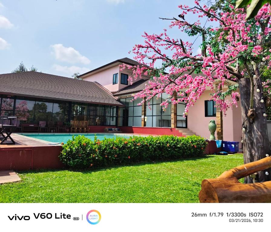 a house with a tree with pink flowers in the yard at 7Zee View เซเว่น ซี วิว in Nakhon Nayok