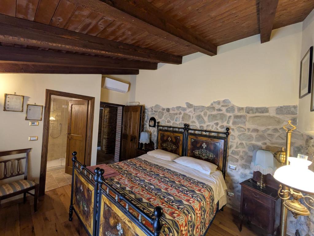 a bedroom with a bed and a stone wall at Agriturismo Farneto in Farneto