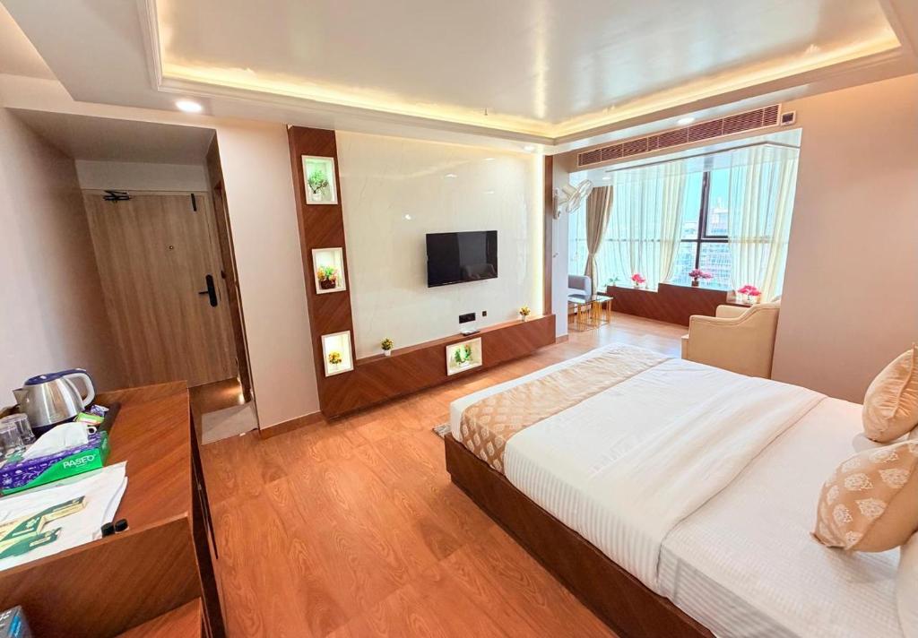 a bedroom with a large bed and a television at Hotel MEDHA Inn in Patna