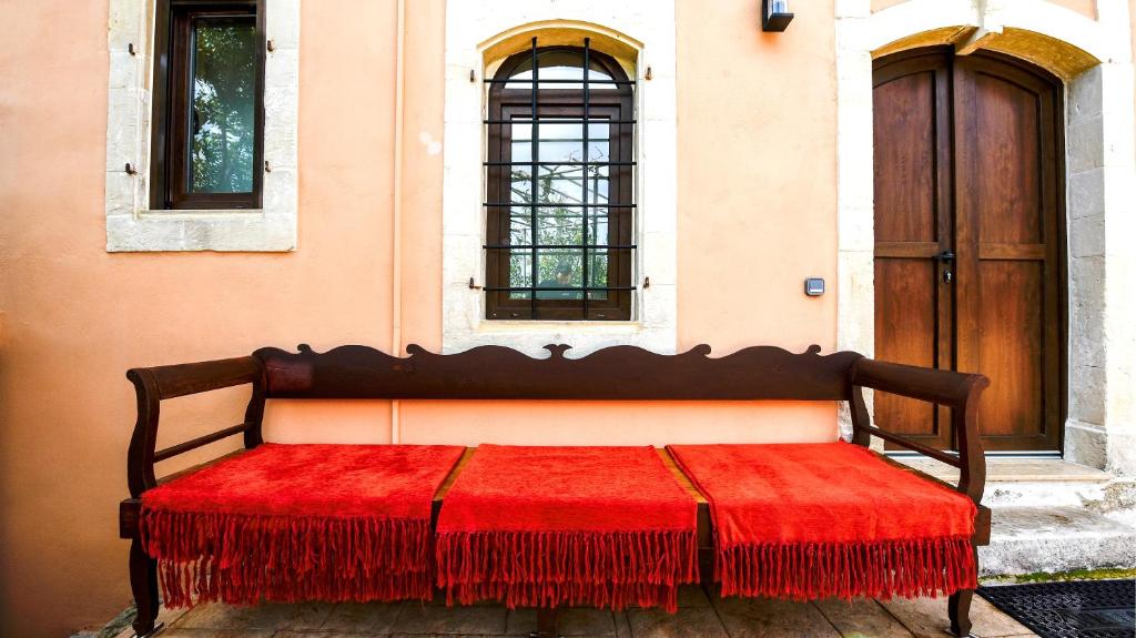 a bench with a red blanket sitting in front of a building at Villa Andrianna in Frés
