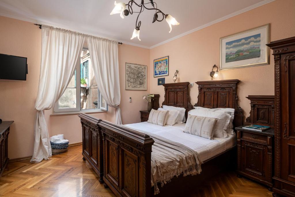 a bedroom with a wooden bed with white pillows at Antaeus Old Town Residence in Dubrovnik