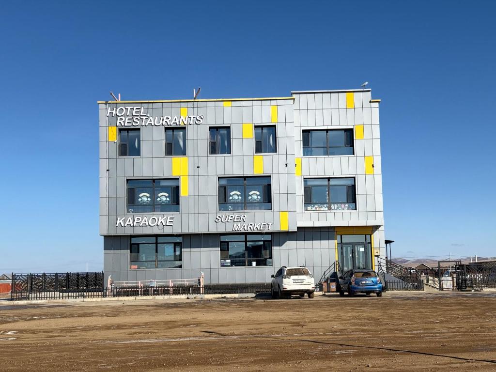 a building with two cars parked in front of it at Onon-Ulz restaurant and hotel in Uldz