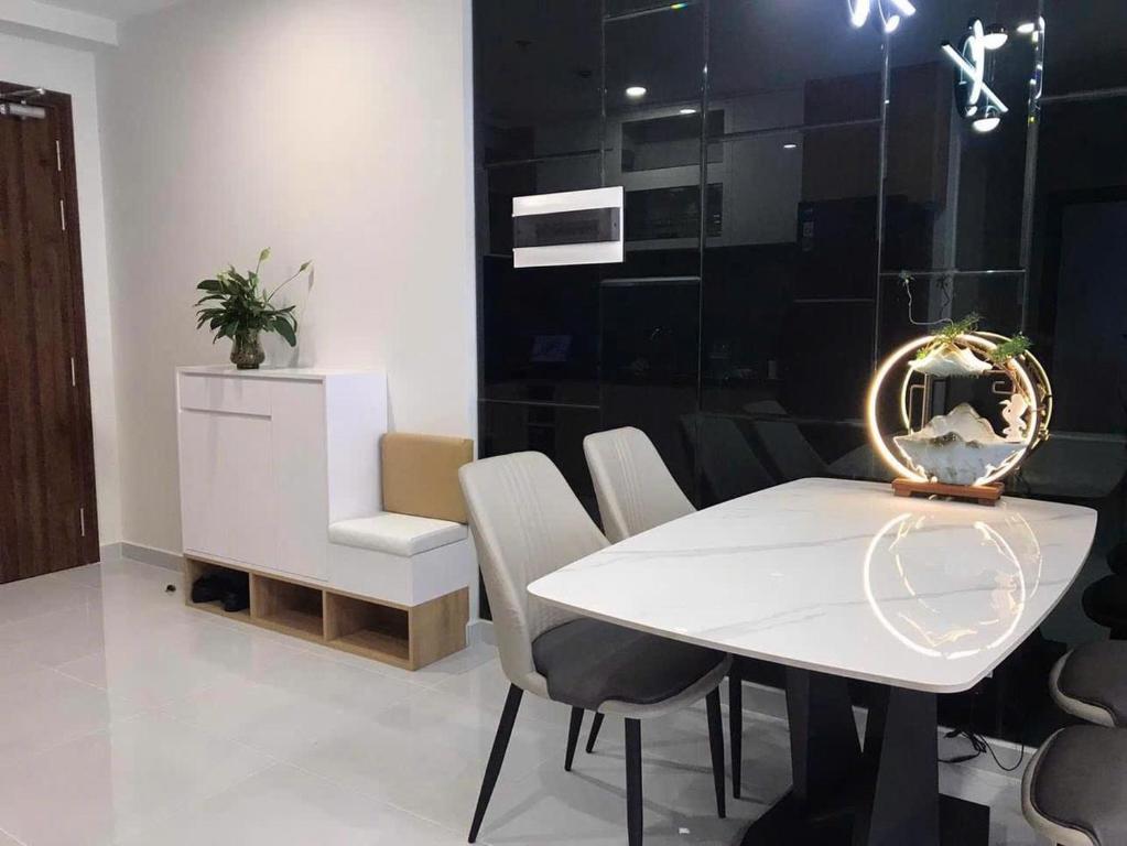 a dining room with a white table and chairs at Căn hộ 2PN THE EMERALD GOLF VIEW in Thuan An
