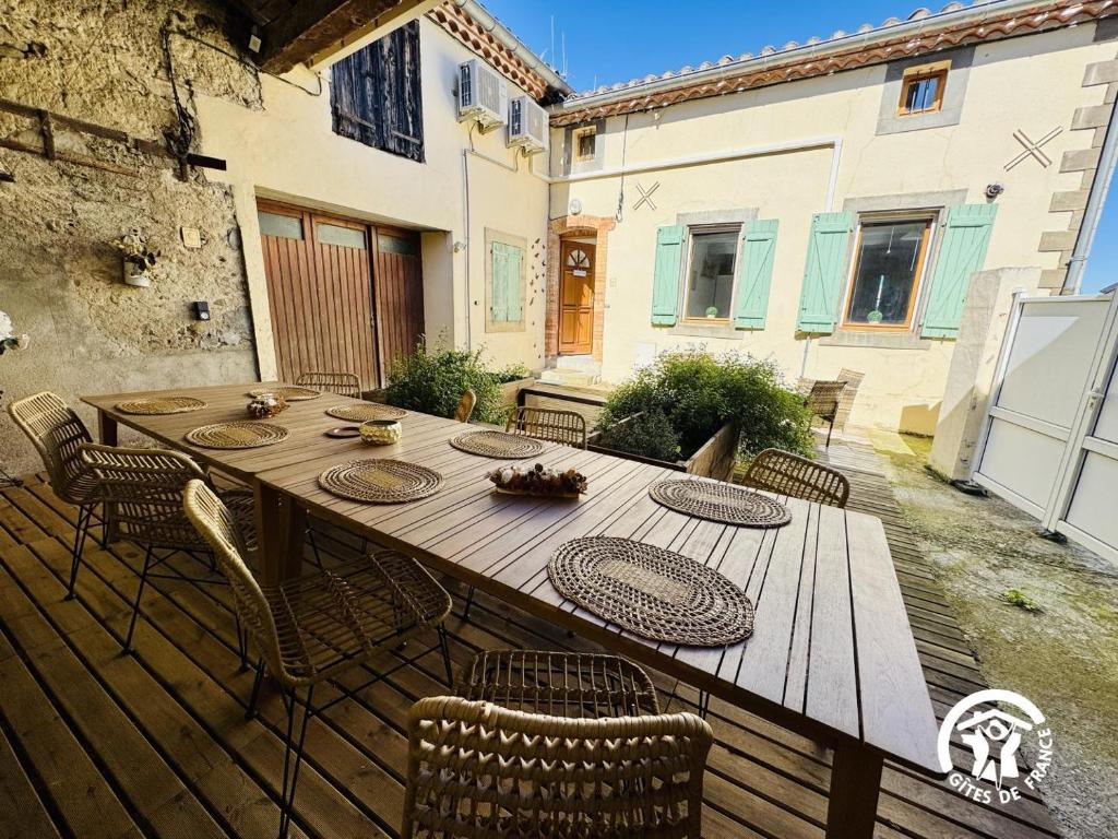 a wooden table and chairs on a wooden deck at Le carpe diem in Pomas