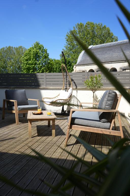un patio con due sedie, un tavolo e una sedia in rattan di Cosy Gare a Caen