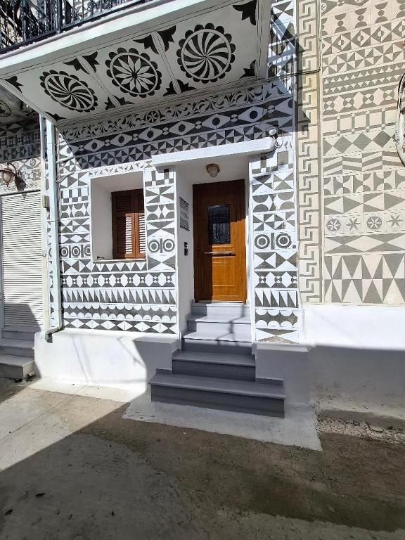 a white house with a wooden door and stairs at Vattediko in Pyrgi