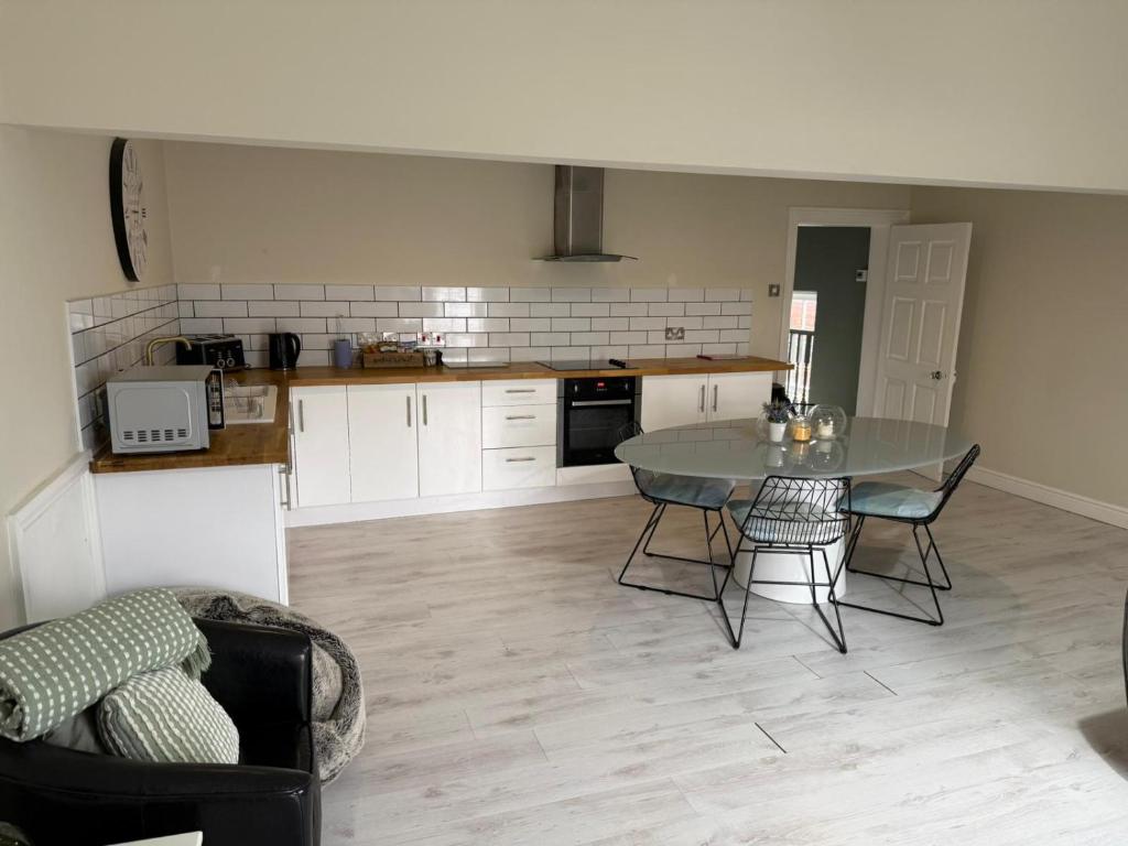 a kitchen with a table and chairs in a room at Townhouse Apartment in Oswestry