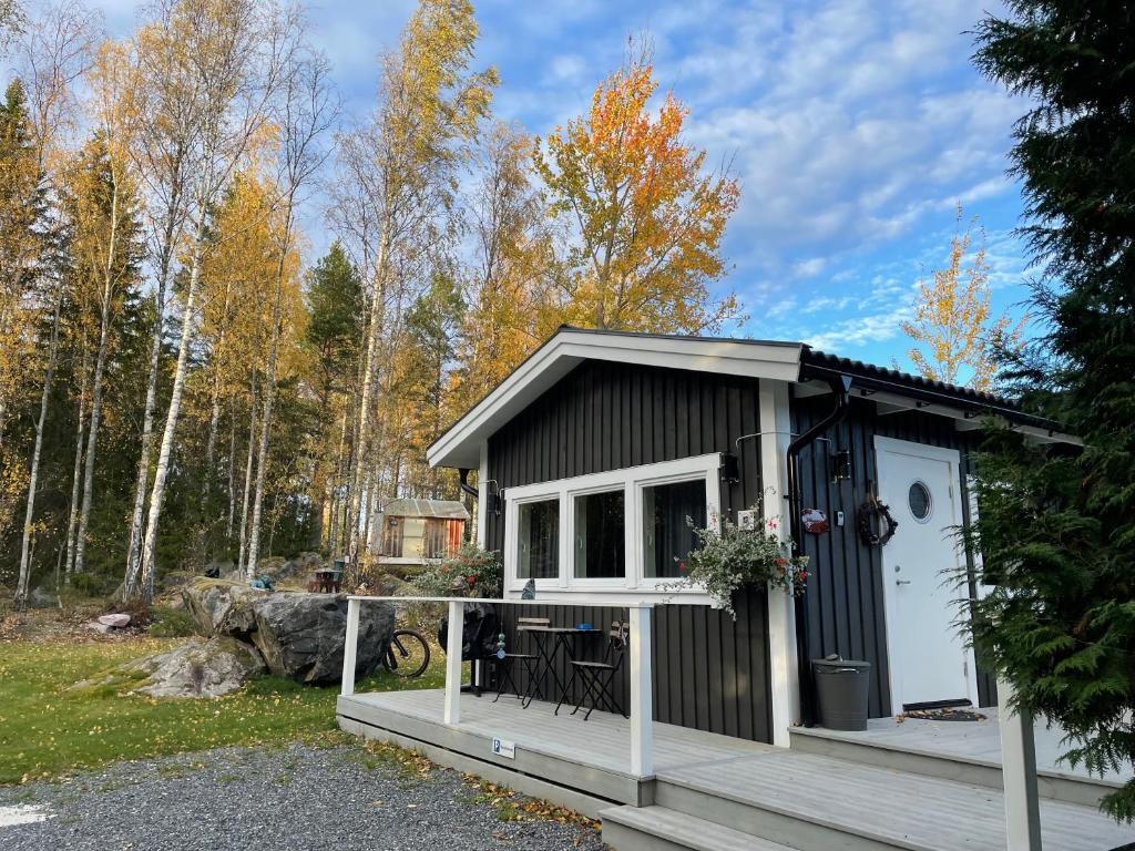 a small black and white shed with a porch at Henar Bed & Breakfast in Gävle